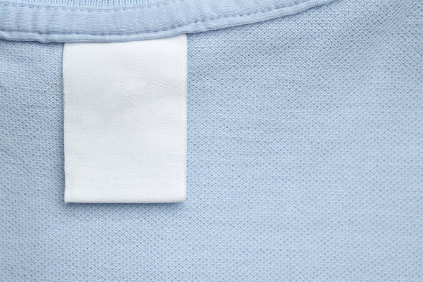 white blank laundry care clothes label on blue shirt fabric background - scale industry copy space special imagens e fotografias de stock