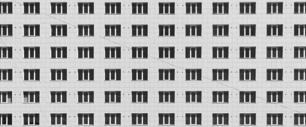 istock Geometric backdrop with lots of window rows. Simple classic design high-rise building. Realistic concept of office building. Apartment house texture background. Many windows on big wall close-up. 1487185704