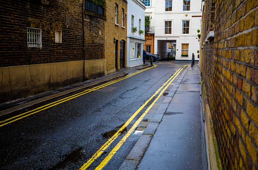 View looking down various mews streets after an early evening shower in the Belgravia section of London, England.  One walkway through the mews is particularly narrow.