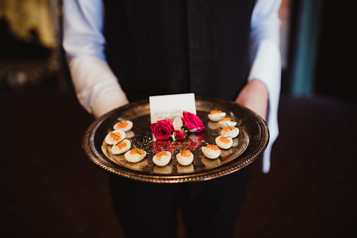 Waiter with deviled eggs on a tray