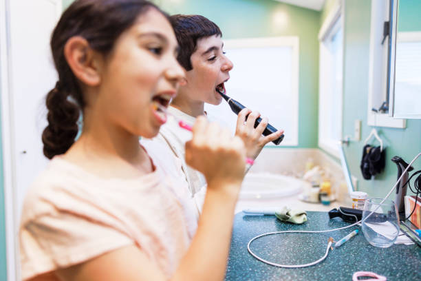 istock Two kids using toothbrushes to clean their teeth in the bathroom 1487201453