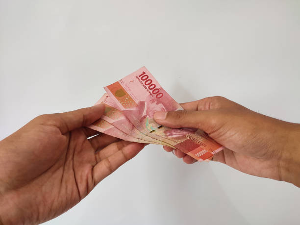 istock Hand giving money on isolated white background 1487202053