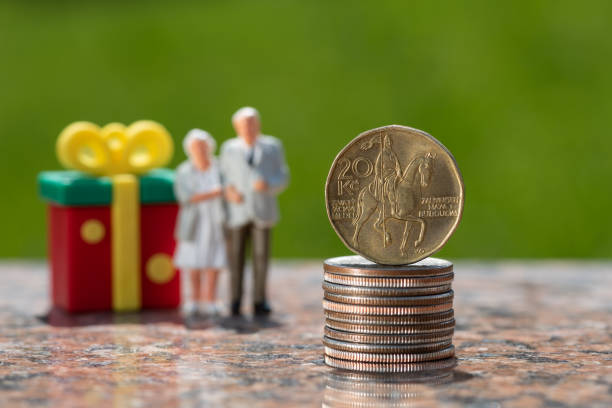 trama conceptual sobre las contribuciones a las pensiones en la república checa con una moneda de 20 coronas checas y figuras de una pareja de ancianos - czech culture currency wealth coin fotografías e imágenes de stock