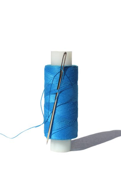 istock A spool of blue thread and a needle is on a white isolated background. 1487204004