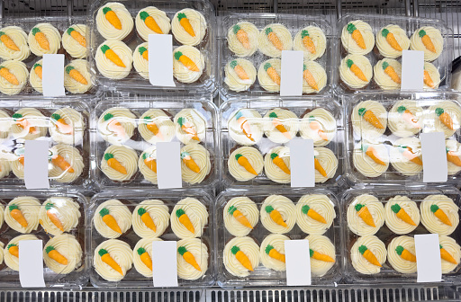 Looking down on a group of carrot cakes in a bakery display