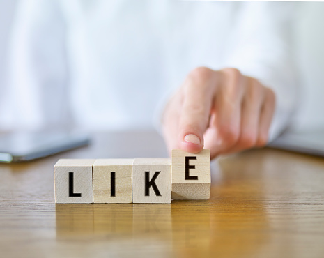 Businesswoman forming ‘Like’ text with cubic blocks