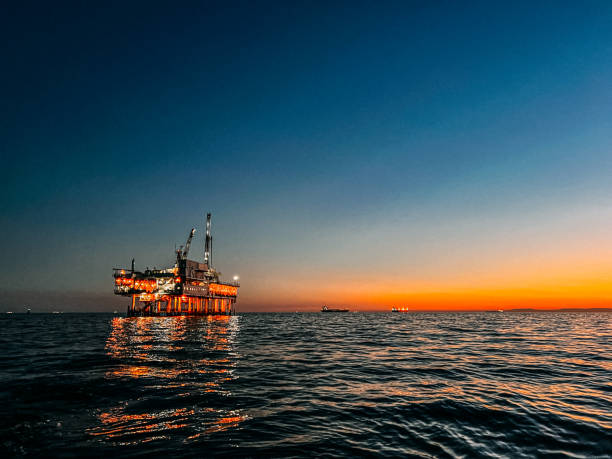 foto espacial de cópia alinhada à esquerda de uma plataforma de perfuração de petróleo offshore ao entardecer perto de huntington beach - oil rig sea oil well oil drill - fotografias e filmes do acervo