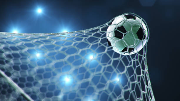 サッカーボールがゴールに飛び込んだ。サッカーボールは、光のフラッシュの背景に対して、ネットを曲げ、ネットを曲げます。青い背景にゴールネットでサッカーボール。喜びの瞬間。3D �
