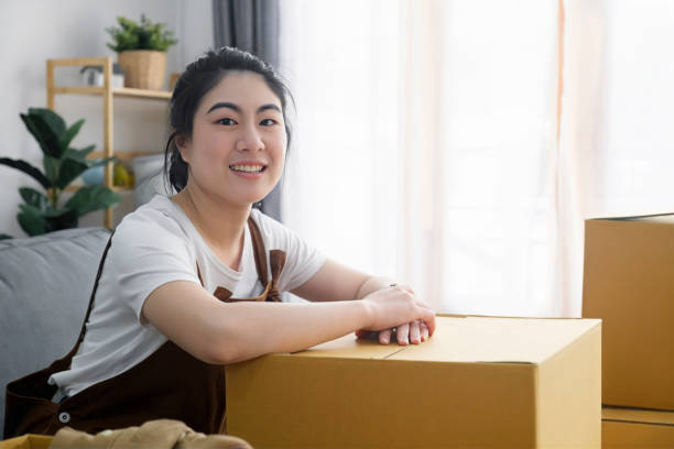 istock Happy woman smiling at home during move with boxes 1487218767