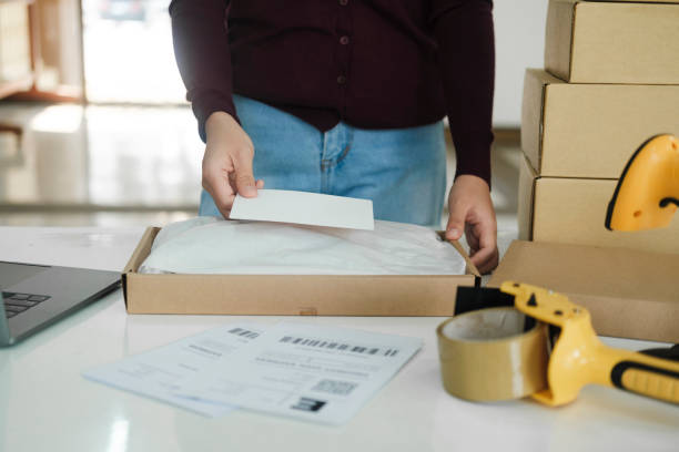 istock Female online business owner packing package. 1487219080