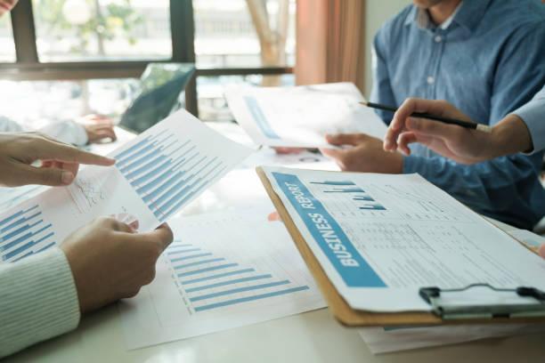 istock Businessmen working together at desk. 1487220280