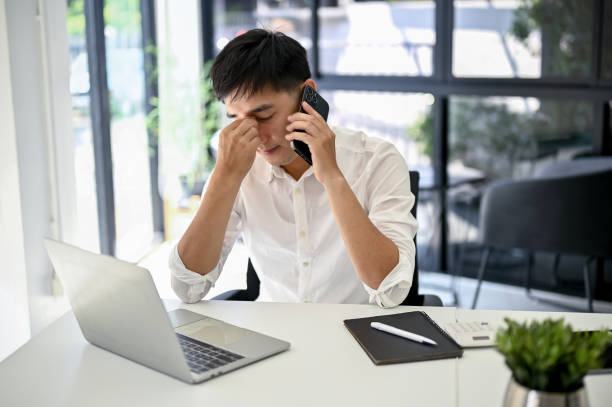 istock Stressed businessman talking on the phone with his worker and fixing the problems over the phone 1487220383