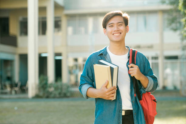 istock Student standing outdoor and holding books. 1487221505