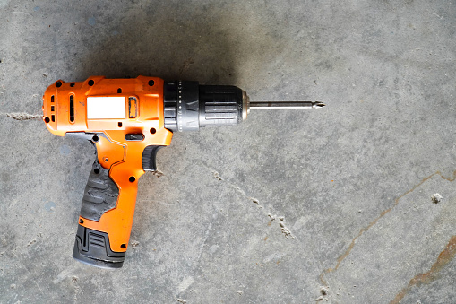 electric cordless screwdriver drill isolated on floor at workshop,top view with copy space.professional home repair tool, hand power tool, copy space, mock up, design