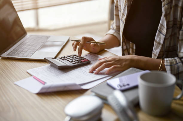 istock Close-up image of a woman using calculator, calculating money 1487222301