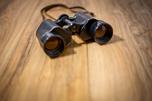 Binoculars isolated on wooden background