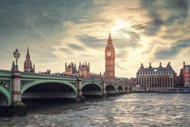 The Big Ben and the Westminster Bridge in London, UK This photo shows the iconic Big Ben and the Westminster Bridge in London, UK. The late afternoon sun casts a warm glow over the scene, creating a contrast between the bright sky and the buildings and the bridge. The sun is partially hidden behind soft clouds, creating a dramatic effect. The river Thames reflects the light and the colors of the sky, adding to the beauty of the photo. The photo captures the essence of London – a city that is both historic and modern, and that has a unique charm and character. london england big ben houses of parliament london international landmark stock pictures, royalty-free photos & images