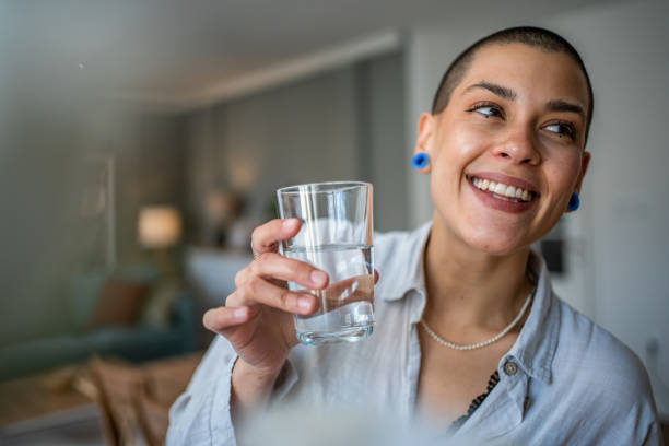 Young beautiful woman drinks water during class, dehydration