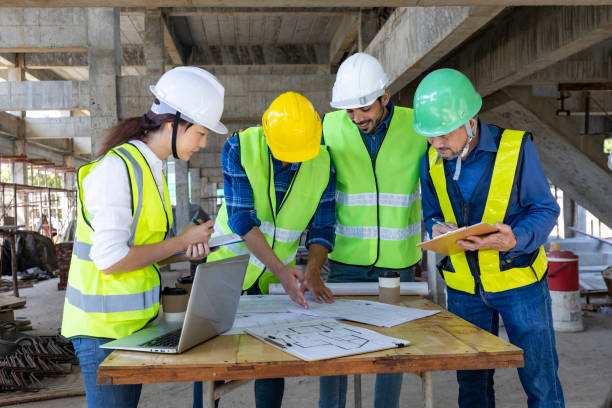 istock Team of engineer, architect, contractor and foreman meeting and consulting at construction building site with floor plan for real estate development project industry and housing timeline 1487230033