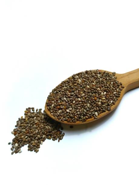 куча семян чиа на ложке, изолированной на белом - tablespoon chia healthy eating seed стоковые фото и изображения