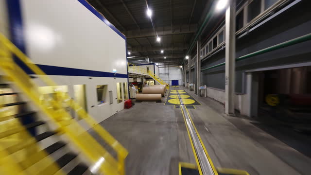 Motion past closed production line and large paper rollers