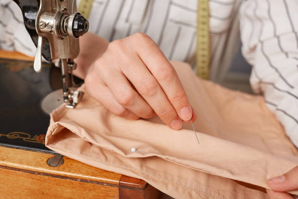 istock Unrecognizable seamstress sewer working on sewing machine, sewing clothes fabric in tailor workshop, making new clothing collection. 1487230343
