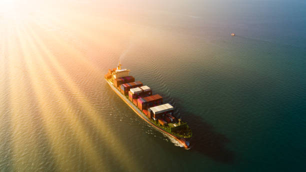 Container ship sailing full speed in the ocean and over sun beam process, Global business logistics import export goods international, cargo transportation industry concept, photograph aerial view, buque portacontenedores navegando a toda velocidad en el océano y sobre el proceso de rayos solares, logística de negocios globales importación de bienes de exportación internacional, concepto de industria de transporte de carga, vista aérea