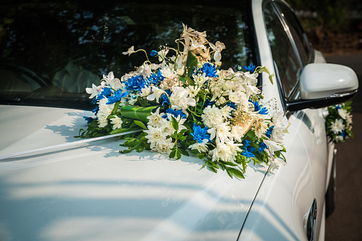 close up of a boutique of flowers on the hood of a wedding car