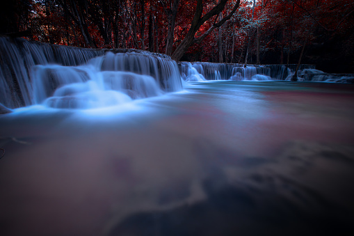long exposure waterfall in the park and change the leaves color over red at huai mae khamin waterfall kanchanaburi Thailand