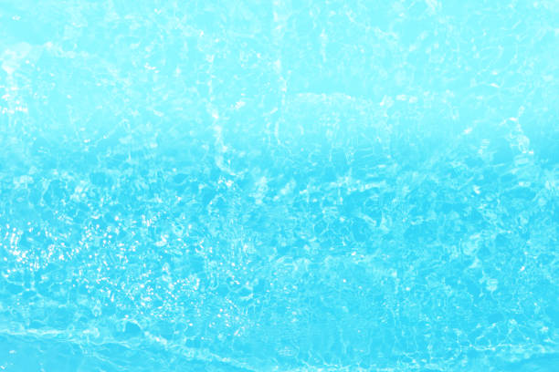 istock Blue water with ripples on the surface. Defocus blurred transparent blue colored clear calm water surface texture with splashes and bubbles. Water waves with shining pattern texture background. 1487237170