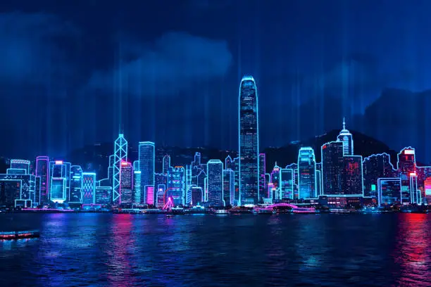 Photo of Cityscape of Hong Kong city skyline at night over Victoria Harbor with reflecting in harbour, Cyberpunk color style.