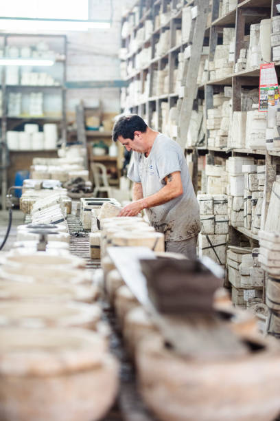 istock Worker removing a clay products from molds in a ceramics factory 1487244784