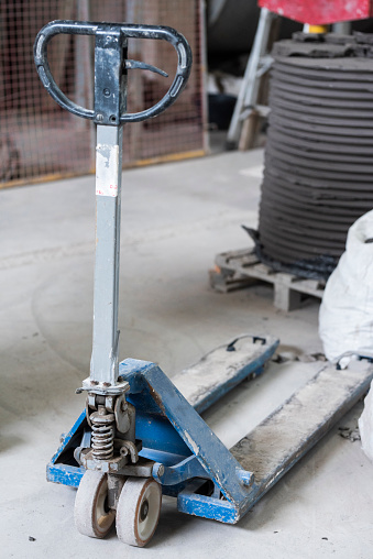 Pallet jack standing on the floor of a ceramics manufacturing factory