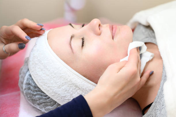 istock A woman cosmetologist washes a client with cotton wool and water, 1487245108