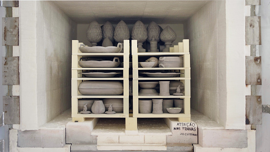Potter's kiln full with clay pots on racks for baking in  ceramics manufacturing factory