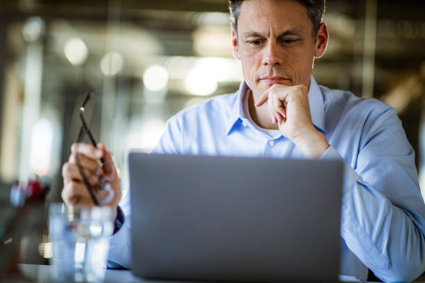 istock Thoughtful entrepreneur reading an e-mail on laptop in the office. 1487249932