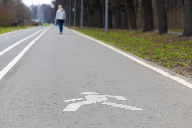 istock walking path in the park with a sign on the pavement. 1487250008