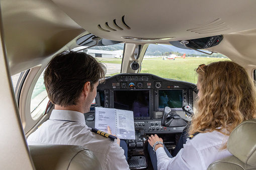 Female and male young pilots preparing private jet for flight