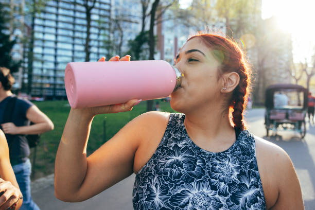 woman jogging in central park - water bottle water bottle drinking imagens e fotografias de stock