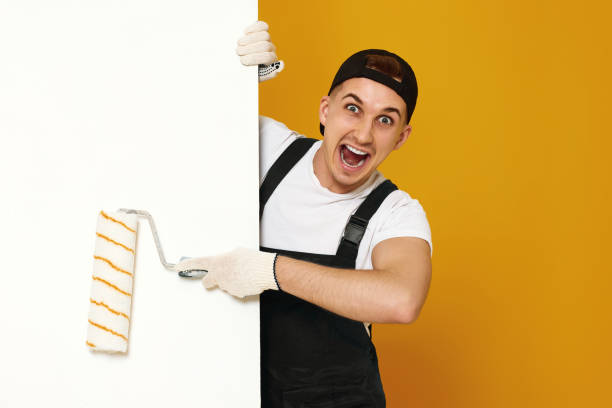istock young man in working clothes painting white walls 1487257708