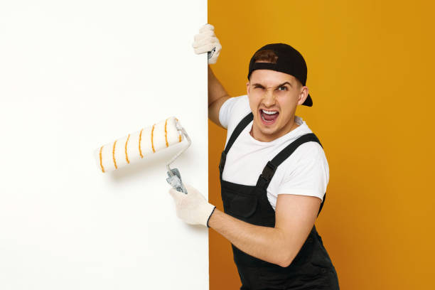 istock young man in working clothes painting white walls 1487257725