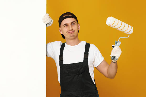 istock young man in working clothes painting white walls 1487257808