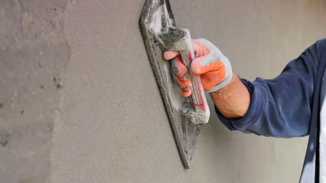 Hand Holding Trowel and Smoothing the Plastering Concrete