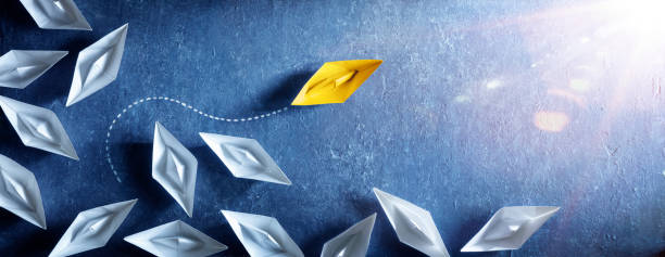 Yellow Paper Boat Change Direction Yellow Paper Boat Change Direction - Leadership Vision And Opportunity - Sailing Against The Tide toy boat stock pictures, royalty-free photos & images