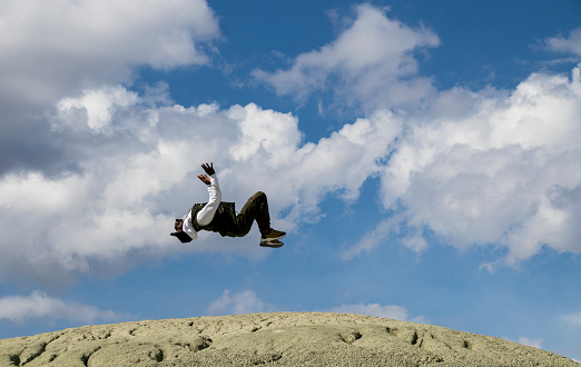 Man doing a backflip on mountain of on top of the mountain. black young dancer man somersaulting