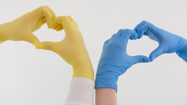 The Ukrainian flag is drawn on hands. Selective focus.gloves blue yellow heart with hands on white background space for text