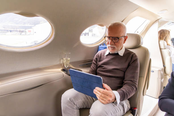 istock Senior business man working on digital tablet in a private jet 1487262726