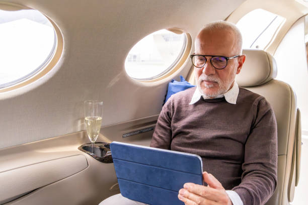 istock Senior business man working on digital tablet in a private jet 1487263430