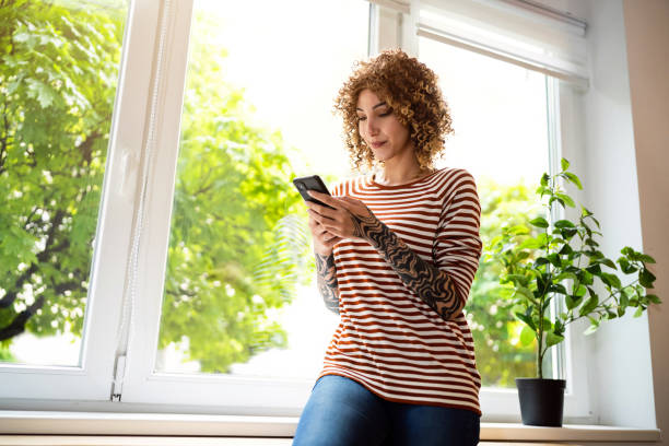 istock Young woman at home texting messages over phone 1487263577