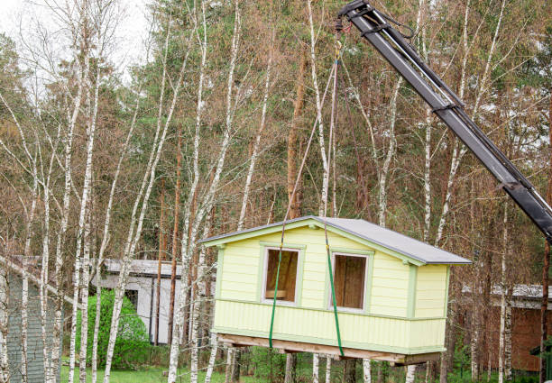 Crane lifting up the tiny house outdoors in spring in nature. stock photo